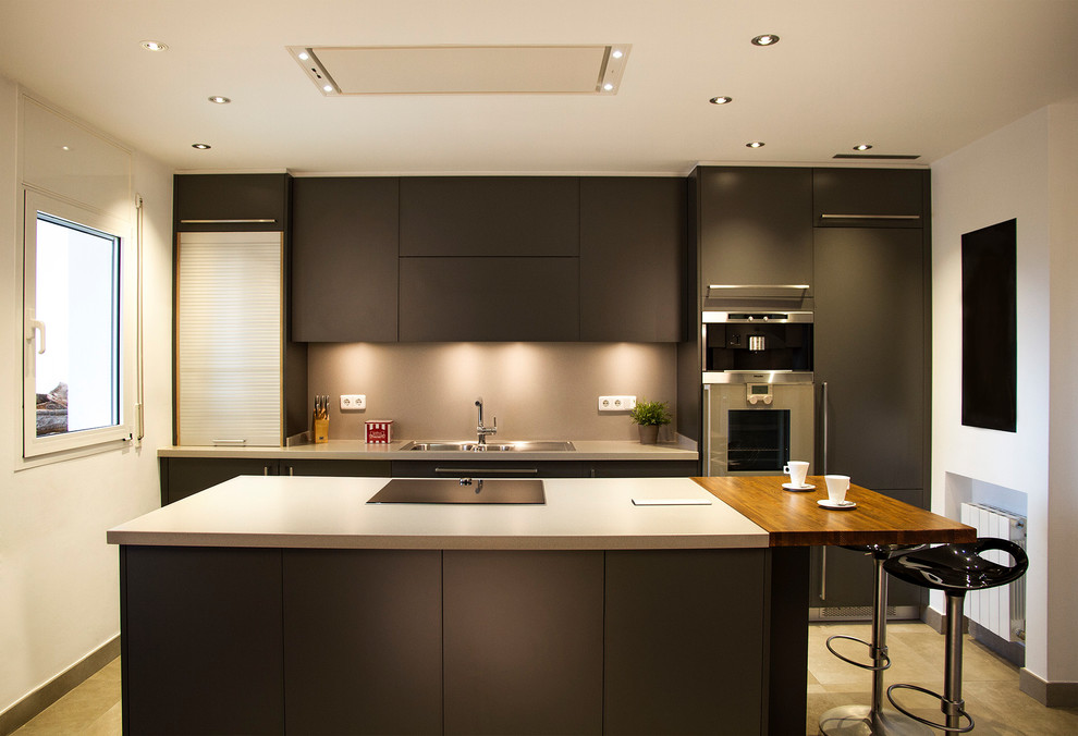 This is an example of a large modern single-wall kitchen/diner in Barcelona with a built-in sink, flat-panel cabinets, grey cabinets, engineered stone countertops, stainless steel appliances, porcelain flooring, an island and grey floors.