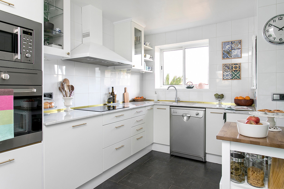 Imagen de cocina retro de tamaño medio con armarios con paneles lisos, puertas de armario blancas, salpicadero blanco y una isla