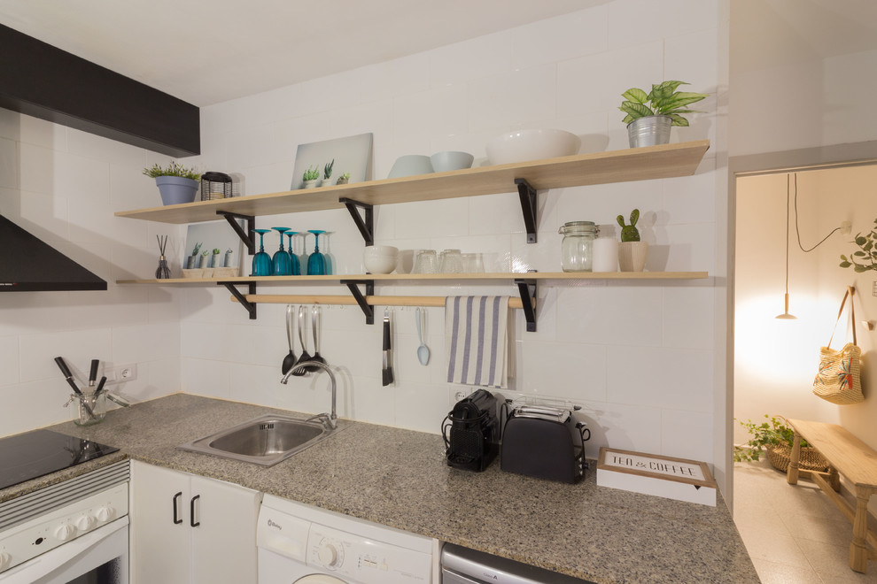 Foto på ett litet maritimt grå kök, med en nedsänkt diskho, öppna hyllor, vita skåp, granitbänkskiva, vitt stänkskydd, stänkskydd i keramik, rostfria vitvaror, klinkergolv i porslin, en halv köksö och grått golv