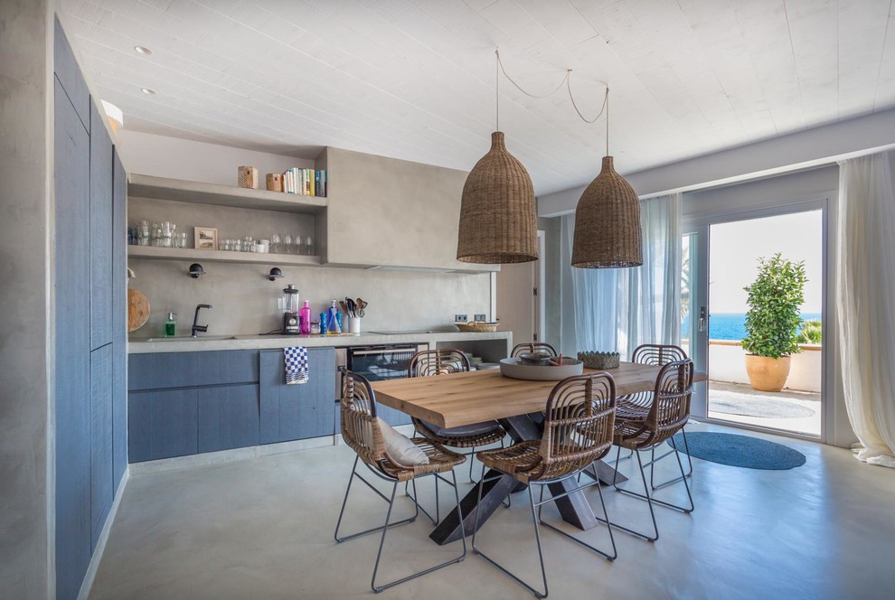 Eat-in kitchen - mid-sized mediterranean l-shaped concrete floor and gray floor eat-in kitchen idea in Other with blue cabinets, concrete countertops, gray backsplash, no island and flat-panel cabinets