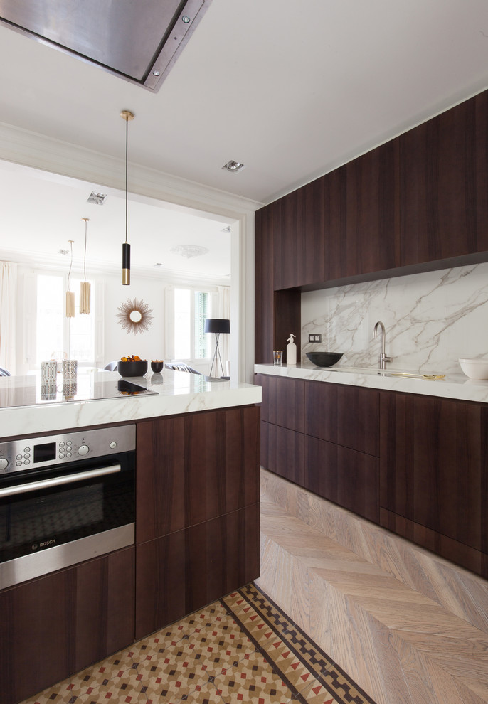 Foto de cocinas en L actual de tamaño medio abierta con encimera de mármol, suelo de madera en tonos medios y suelo marrón