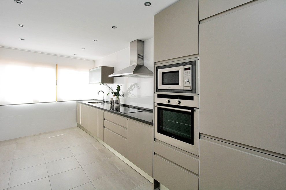 Photo of a medium sized classic single-wall enclosed kitchen in Malaga with a single-bowl sink, flat-panel cabinets, stainless steel appliances, ceramic flooring and no island.