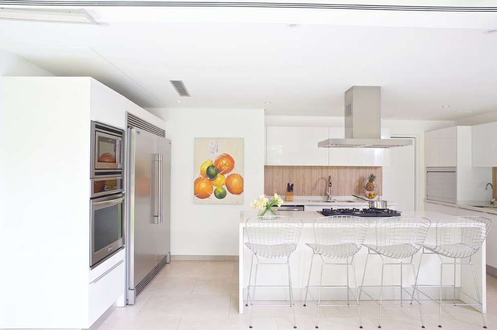 Exempel på ett mellanstort modernt vit vitt kök, med en undermonterad diskho, släta luckor, vita skåp, bänkskiva i kvarts, brunt stänkskydd, stänkskydd i trä, rostfria vitvaror, marmorgolv, en köksö och beiget golv