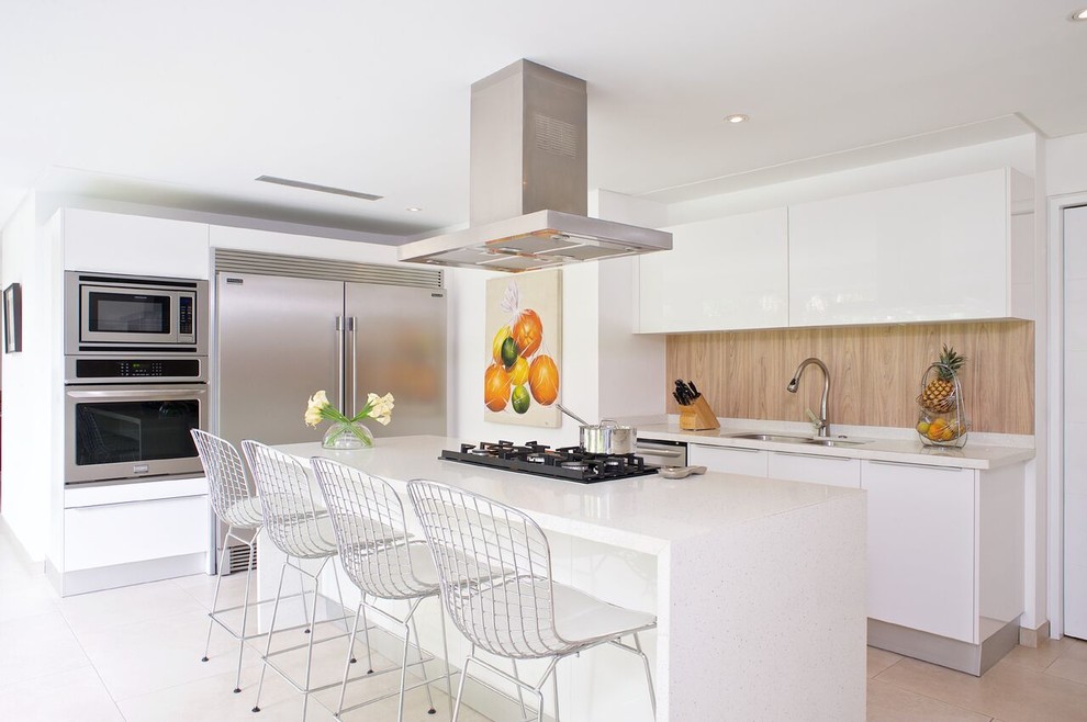 Photo of a medium sized contemporary u-shaped open plan kitchen in Other with a submerged sink, flat-panel cabinets, white cabinets, engineered stone countertops, brown splashback, wood splashback, stainless steel appliances, marble flooring, an island, beige floors and white worktops.