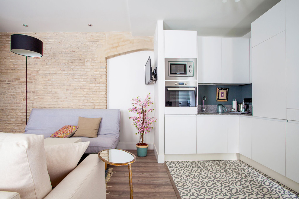 Einzeilige, Mittelgroße Moderne Wohnküche ohne Insel mit flächenbündigen Schrankfronten, weißen Schränken, Granit-Arbeitsplatte und Küchenrückwand in Blau in Sevilla