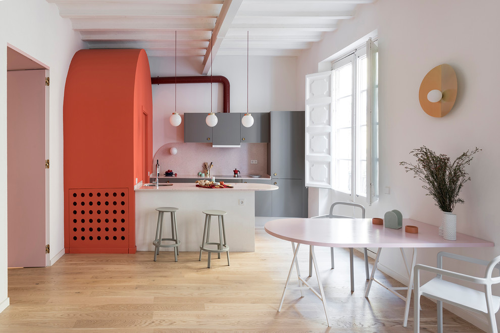 Foto de cocina contemporánea con armarios con paneles lisos, puertas de armario grises, suelo de madera clara, península y suelo beige
