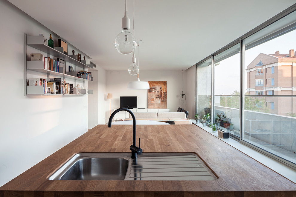 Modelo de cocina lineal minimalista de tamaño medio abierta con suelo de madera en tonos medios y una isla