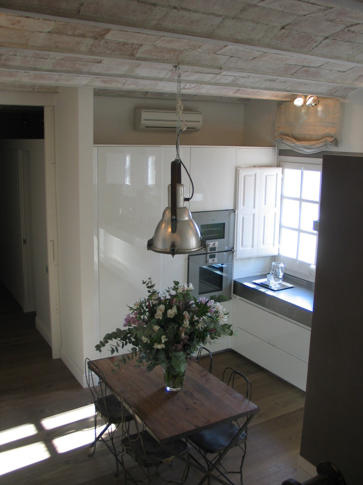 На фото: угловая кухня-гостиная среднего размера в современном стиле с столешницей из нержавеющей стали без острова с