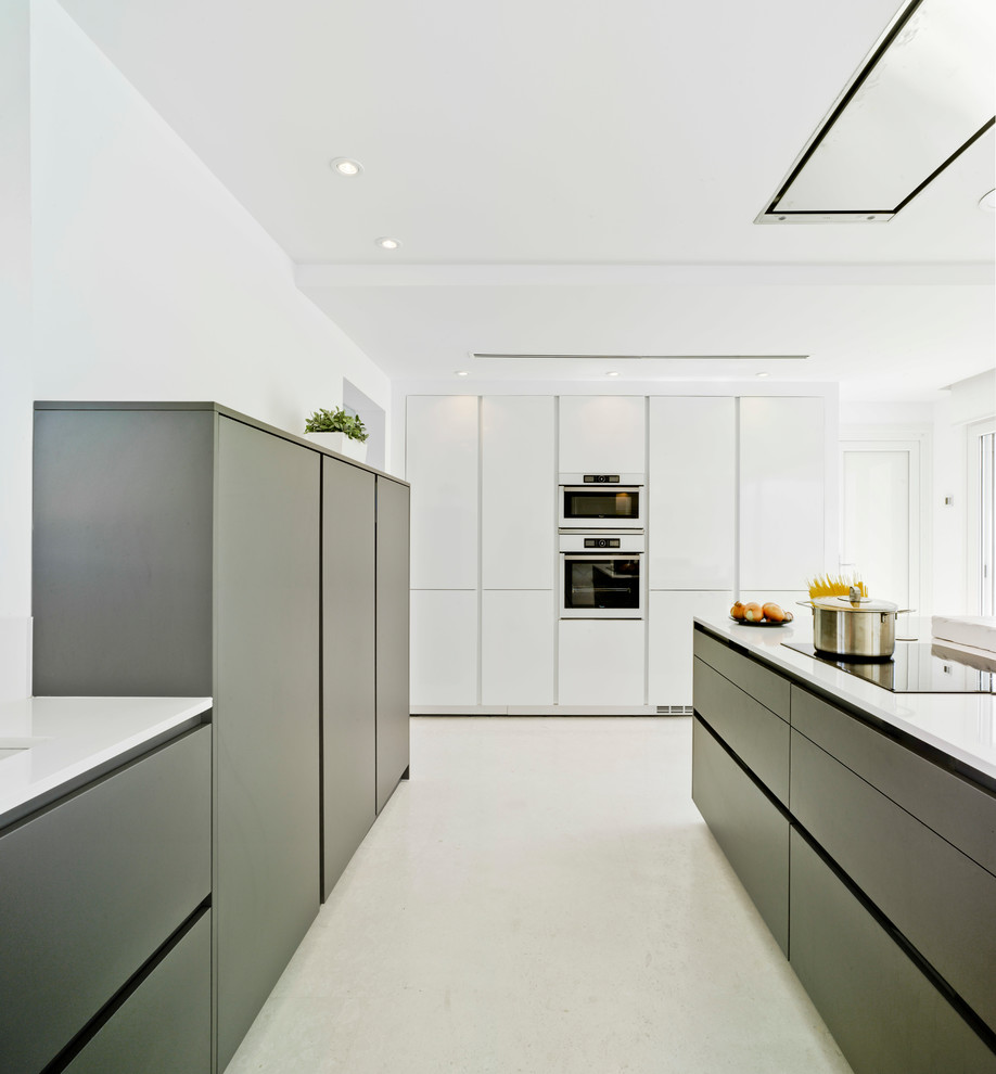 Ejemplo de cocina lineal contemporánea de tamaño medio abierta con armarios con paneles lisos, puertas de armario negras, una isla y encimeras blancas