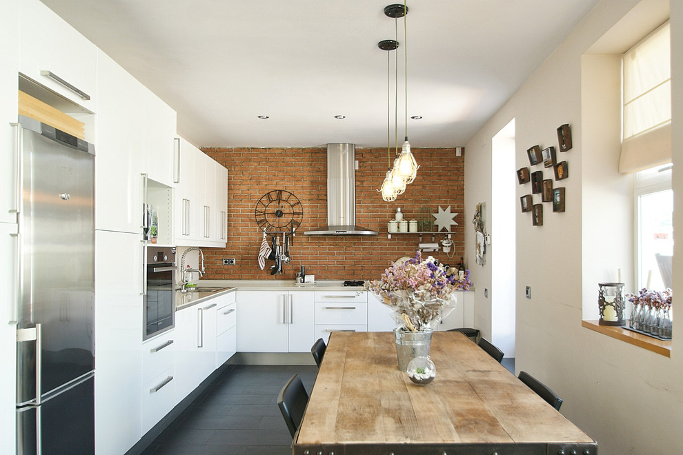 На фото: угловая кухня среднего размера в стиле лофт с обеденным столом, плоскими фасадами, белыми фасадами и полом из керамической плитки с