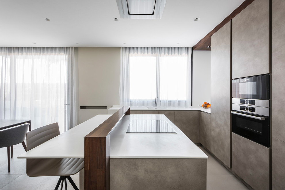Moderne Wohnküche in L-Form mit flächenbündigen Schrankfronten, beigen Schränken, Kücheninsel, beigem Boden und weißer Arbeitsplatte in Valencia