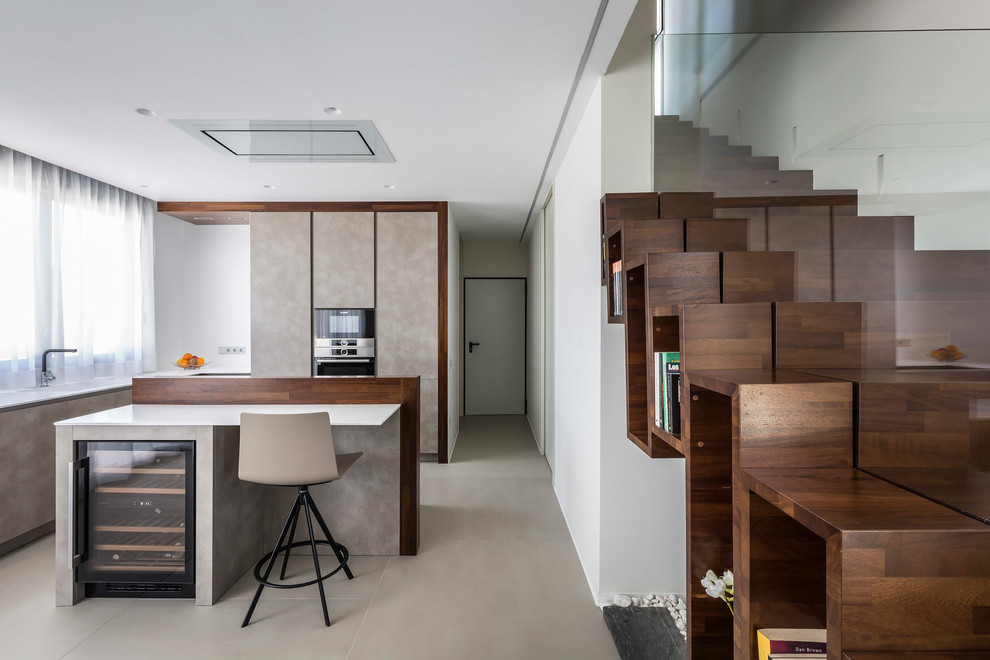 Moderne Wohnküche in L-Form mit flächenbündigen Schrankfronten, beigen Schränken, Kücheninsel, beigem Boden und weißer Arbeitsplatte in Valencia