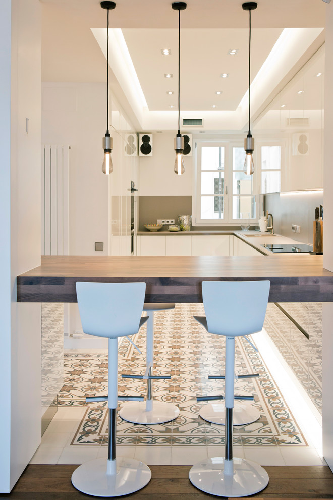 Große Moderne Küche mit flächenbündigen Schrankfronten, weißen Schränken, Quarzwerkstein-Arbeitsplatte, Zementfliesen für Boden, buntem Boden, Küchenrückwand in Grau und grauer Arbeitsplatte in Barcelona