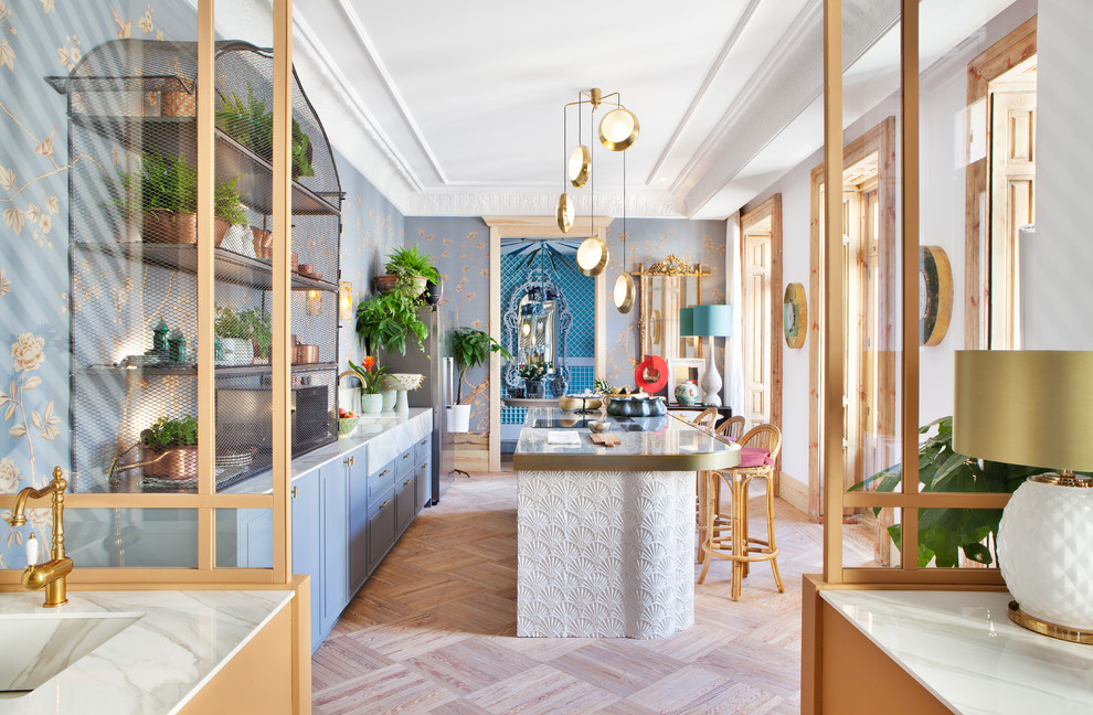 Zweizeilige Stilmix Küche mit Unterbauwaschbecken, profilierten Schrankfronten, blauen Schränken, Küchengeräten aus Edelstahl, Kücheninsel, beigem Boden und weißer Arbeitsplatte in Madrid