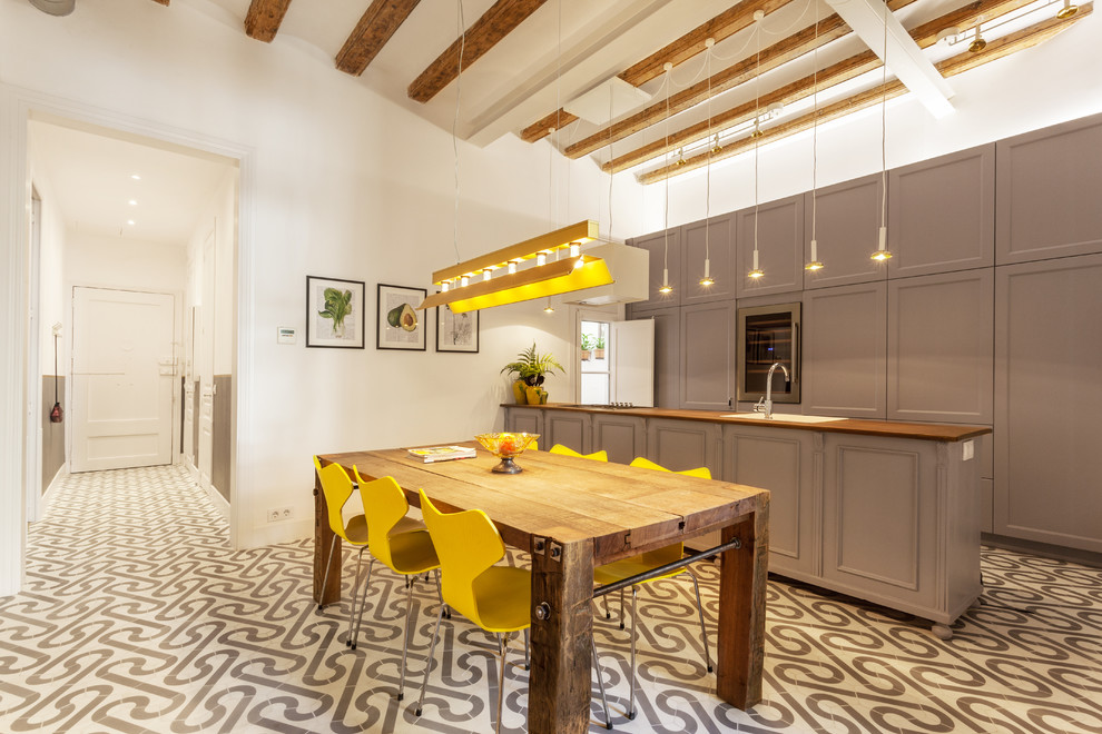 This is an example of a large scandinavian single-wall kitchen/diner in Barcelona with recessed-panel cabinets, grey cabinets, wood worktops, ceramic flooring and a breakfast bar.