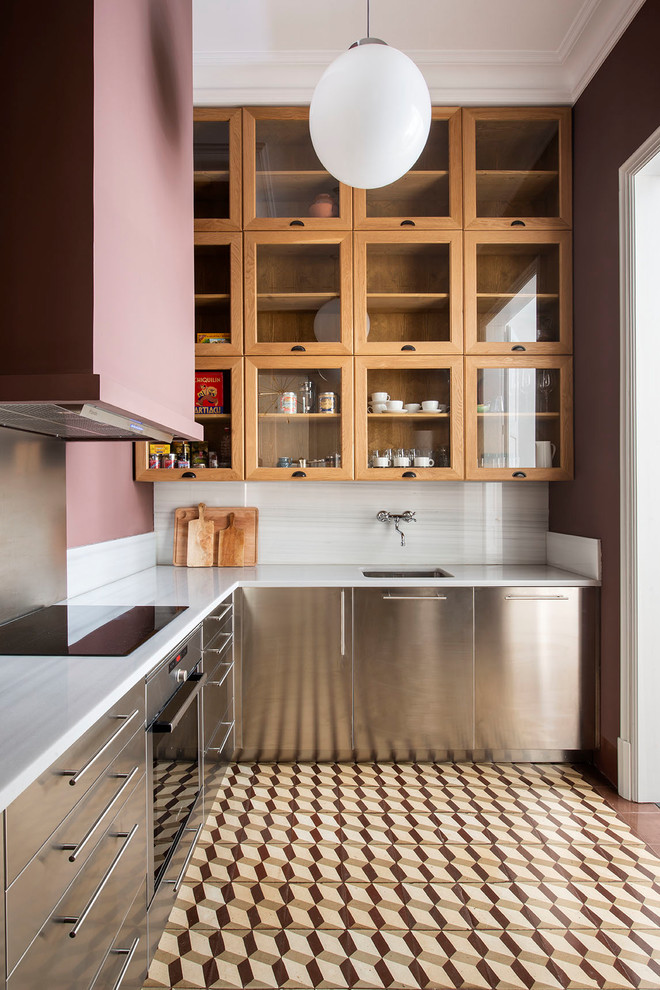 Design ideas for a traditional l-shaped kitchen in Barcelona with a submerged sink, stainless steel cabinets, white splashback, stainless steel appliances, white worktops, flat-panel cabinets, stone slab splashback and brown floors.