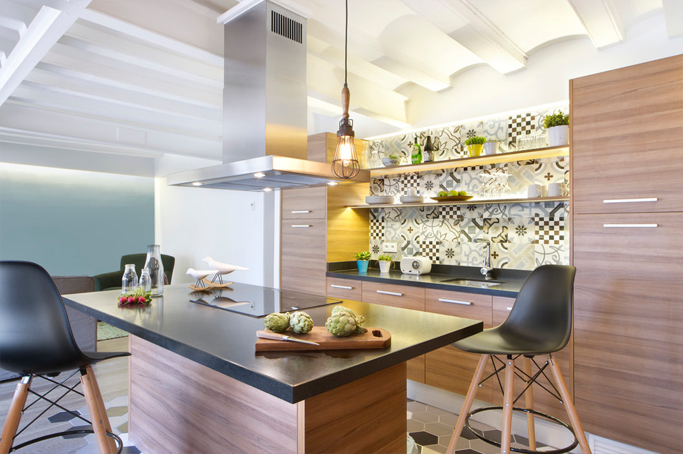 Medium sized contemporary galley open plan kitchen in Madrid with a submerged sink, flat-panel cabinets, medium wood cabinets, composite countertops, multi-coloured splashback, ceramic splashback, stainless steel appliances, ceramic flooring, an island and black worktops.