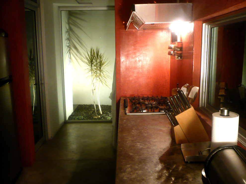 Idéer för ett avskilt, litet modernt linjärt kök, med en rustik diskho, öppna hyllor, bänkskiva i betong, rött stänkskydd, spegel som stänkskydd, rostfria vitvaror, betonggolv och grått golv