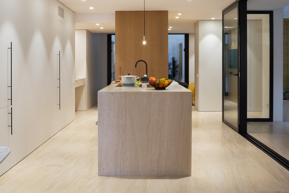 Immagine di una cucina moderna con ante lisce, ante bianche, top in pietra calcarea, pavimento in pietra calcarea, pavimento marrone e top marrone