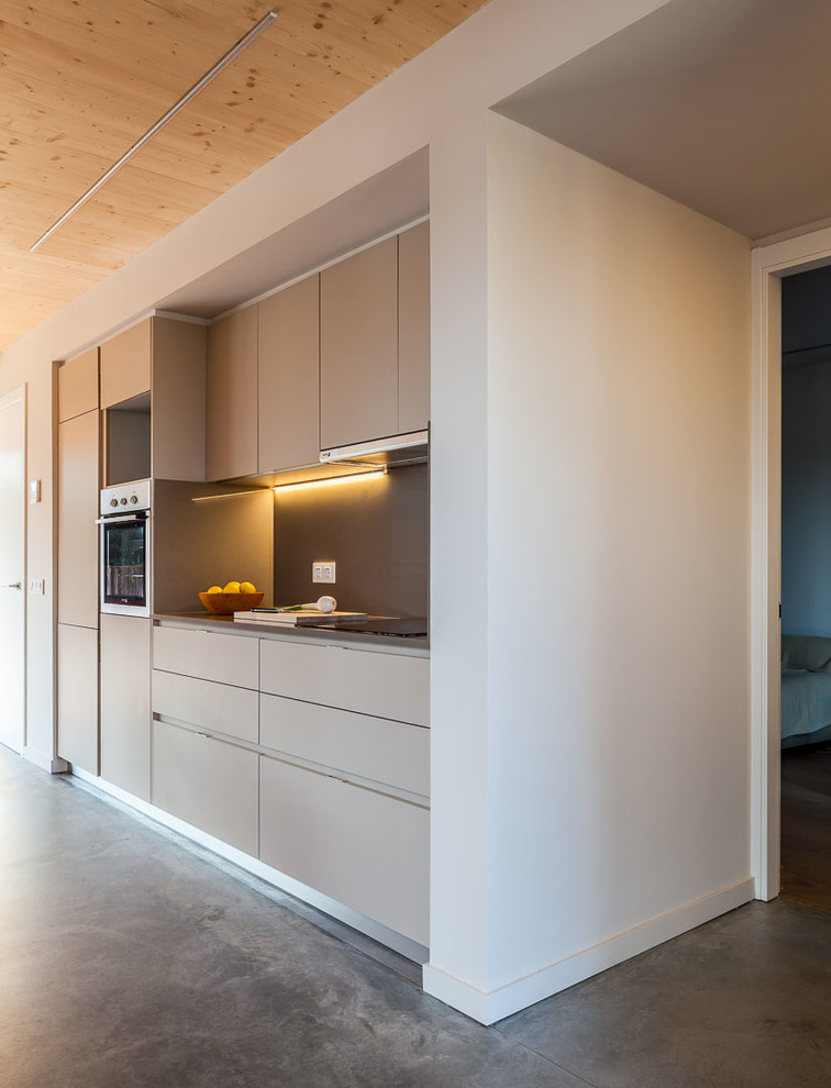 Cette photo montre une cuisine tendance avec un placard à porte plane, un sol gris et un plan de travail gris.
