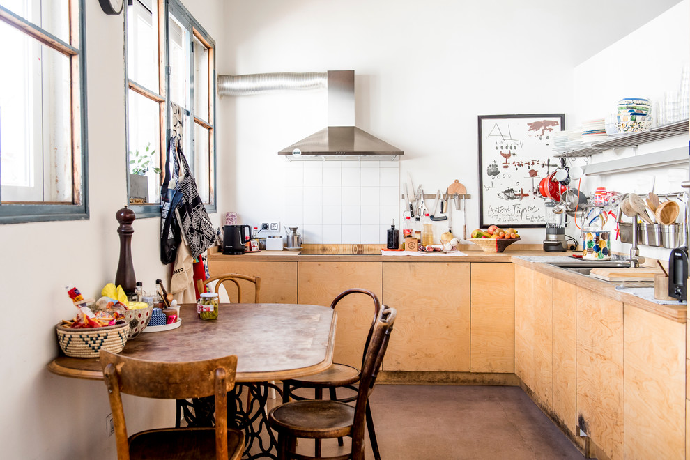 Mid-sized eclectic l-shaped eat-in kitchen photo in Madrid with flat-panel cabinets, medium tone wood cabinets, wood countertops, white backsplash, ceramic backsplash and no island