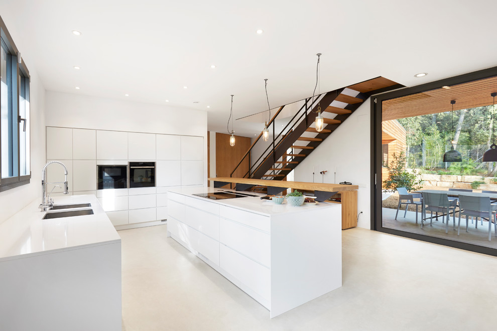 Expansive scandinavian galley open plan kitchen in Other with flat-panel cabinets, white cabinets, white splashback, an island and beige floors.