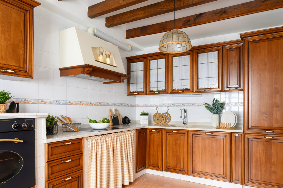 Kitchen - mid-sized mediterranean l-shaped porcelain tile, beige floor and exposed beam kitchen idea in Other with an undermount sink, raised-panel cabinets, medium tone wood cabinets, white backsplash, porcelain backsplash and beige countertops