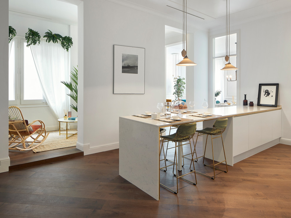 Idéer för att renovera ett skandinaviskt linjärt kök med öppen planlösning, med en undermonterad diskho, släta luckor, vita skåp, marmorbänkskiva, stänkskydd i marmor, vita vitvaror, mörkt trägolv och en köksö