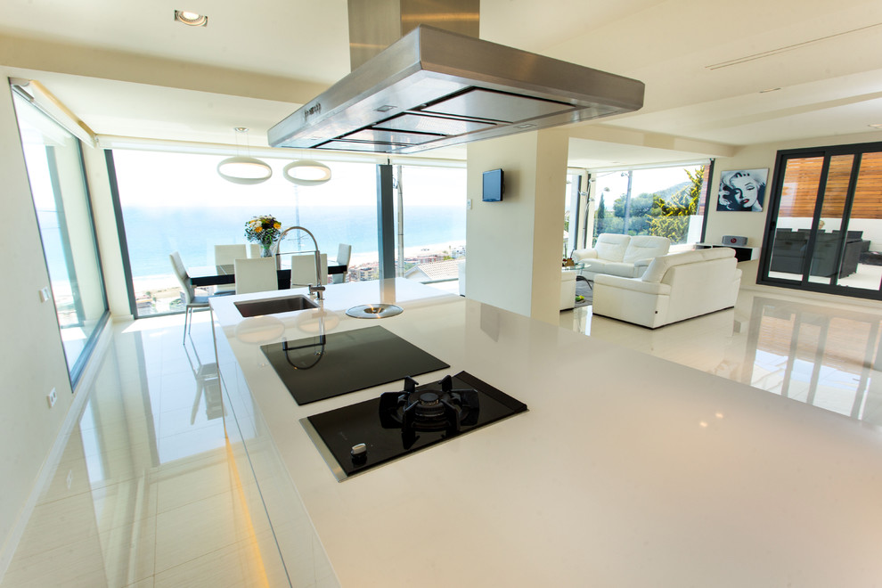 Modelo de cocina lineal moderna grande abierta con armarios con paneles lisos, puertas de armario blancas y una isla