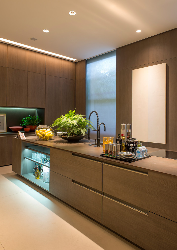 Aménagement d'une grande cuisine ouverte linéaire moderne en bois clair avec un placard à porte plane, îlot et un sol beige.