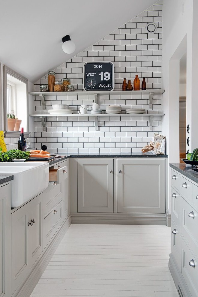 Enclosed kitchen - small contemporary galley painted wood floor enclosed kitchen idea in Madrid with a farmhouse sink, recessed-panel cabinets, gray cabinets, white backsplash, subway tile backsplash and no island