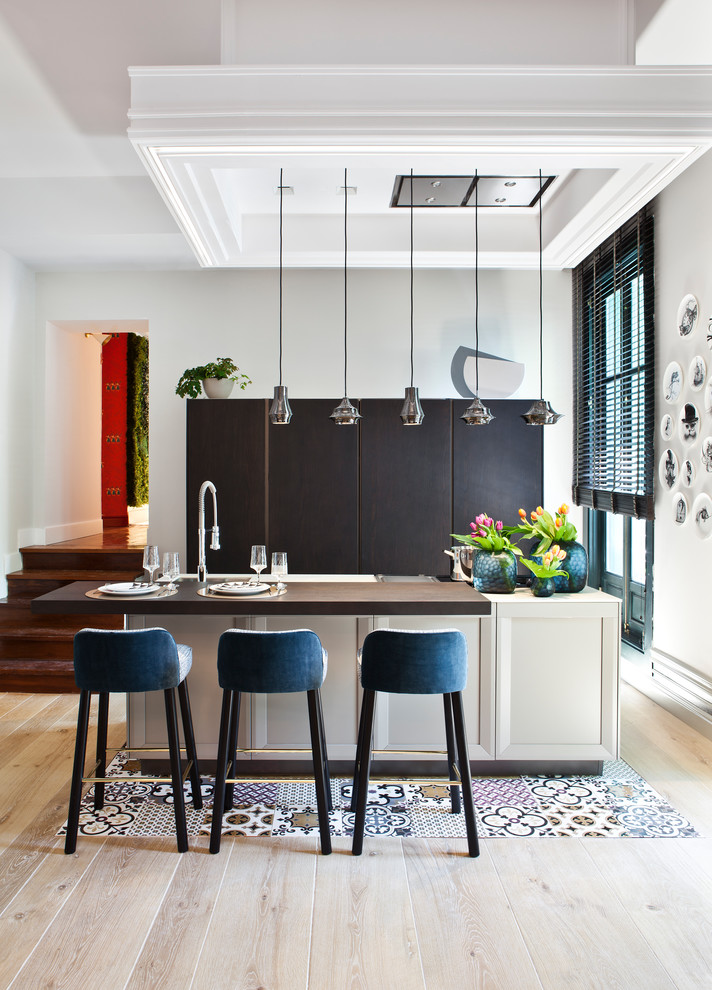 Diseño de cocina lineal contemporánea de tamaño medio abierta con puertas de armario negras, una isla y encimeras marrones