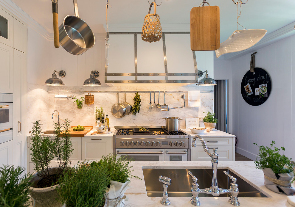 Example of a mid-sized mountain style galley eat-in kitchen design in Madrid with an undermount sink, raised-panel cabinets, white cabinets, stainless steel appliances and an island