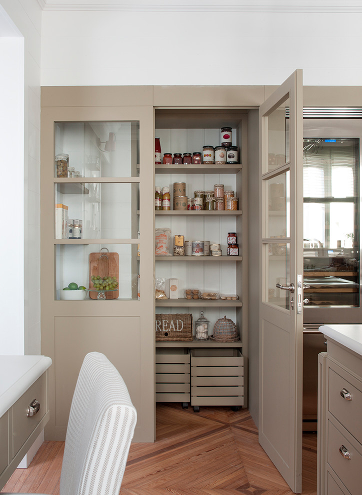 Photo of a classic kitchen pantry in Barcelona with an integrated sink, beige cabinets, engineered stone countertops, white splashback, ceramic splashback, stainless steel appliances, light hardwood flooring, an island and brown floors.