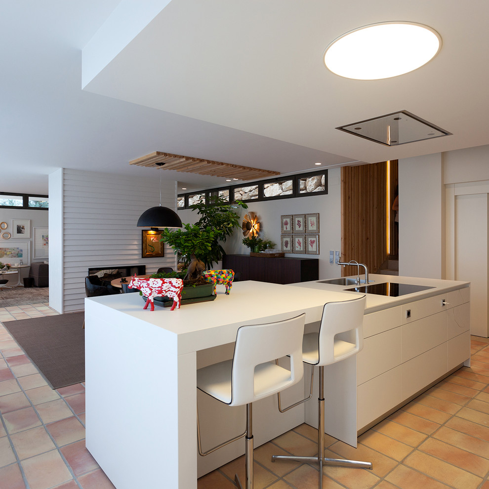 Idéer för funkis linjära vitt kök med öppen planlösning, med släta luckor, vita skåp och en köksö