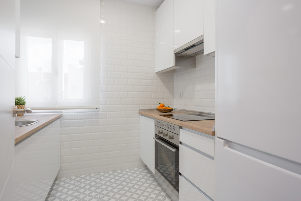 Diseño de cocina lineal minimalista cerrada con armarios con paneles lisos, puertas de armario blancas, encimera de laminado, electrodomésticos con paneles, suelo de baldosas de porcelana y encimeras marrones