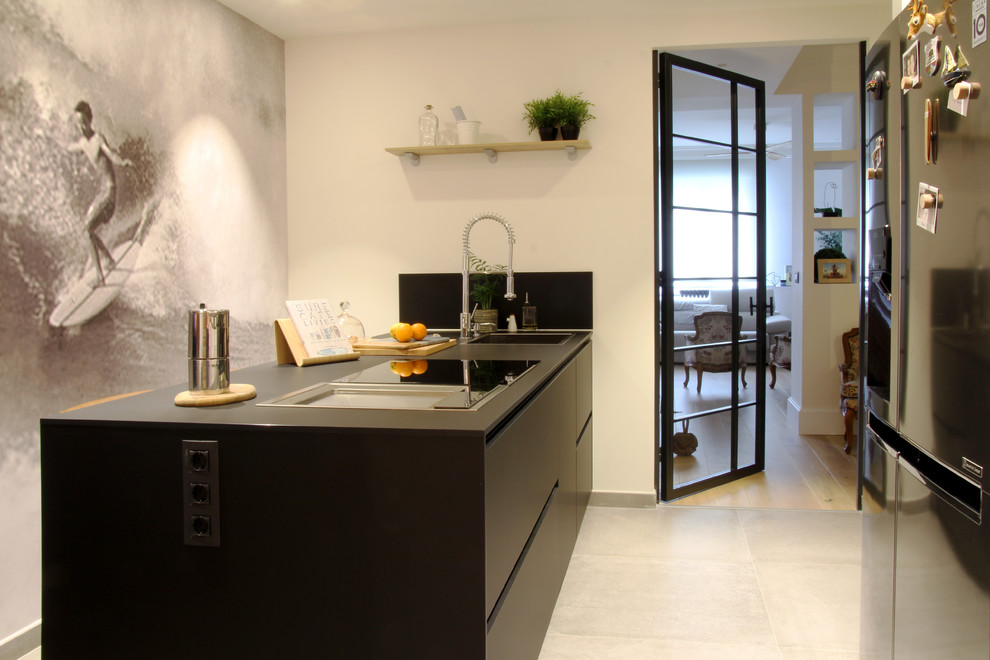 Geschlossene, Einzeilige, Mittelgroße Moderne Küche mit Waschbecken, schwarzen Schränken, Küchengeräten aus Edelstahl, Kücheninsel, grauem Boden und schwarzer Arbeitsplatte in Bilbao