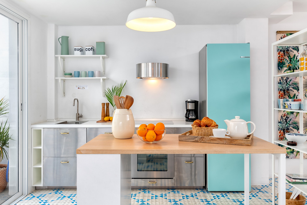 Inspiration for a mediterranean single-wall multicolored floor kitchen remodel with an undermount sink, flat-panel cabinets, stainless steel cabinets, colored appliances, an island and white countertops