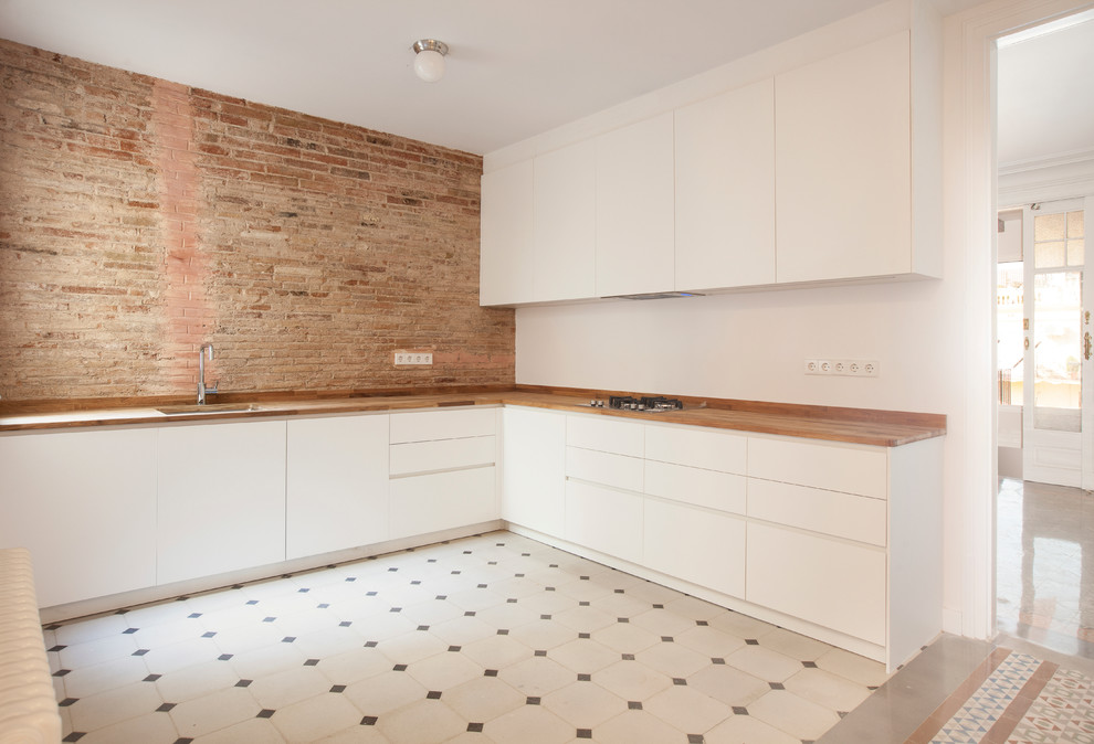 Medium sized contemporary l-shaped open plan kitchen in Barcelona with a single-bowl sink, flat-panel cabinets, white cabinets, wood worktops, white splashback, ceramic flooring and no island.