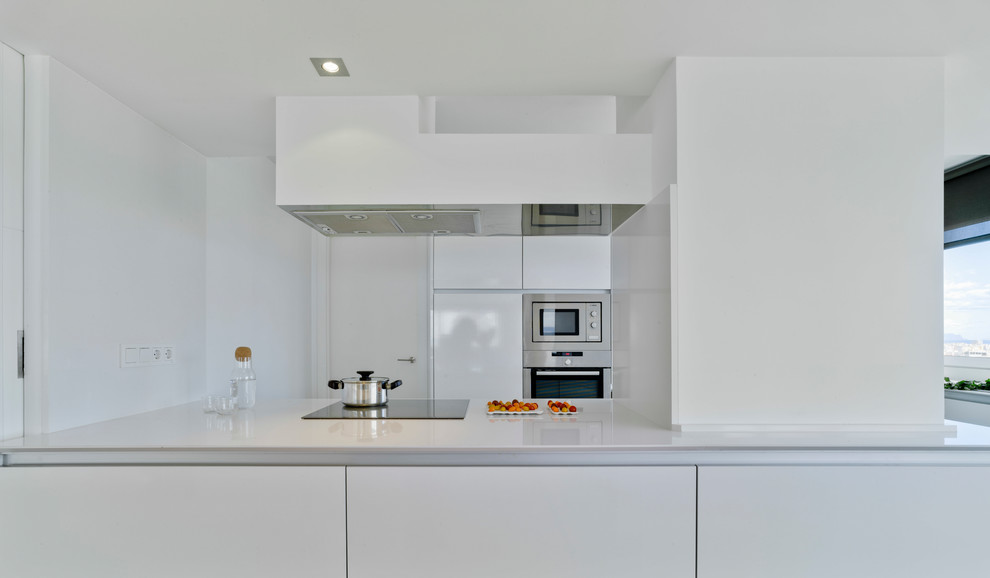 Photo of a large contemporary single-wall open plan kitchen in Alicante-Costa Blanca with flat-panel cabinets, white cabinets, engineered stone countertops, light hardwood flooring, no island and beige floors.