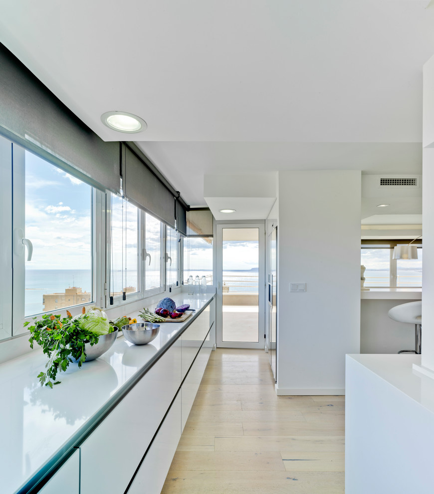 Стильный дизайн: большая прямая кухня-гостиная в современном стиле с плоскими фасадами, белыми фасадами, столешницей из кварцевого агломерата, светлым паркетным полом и бежевым полом без острова - последний тренд