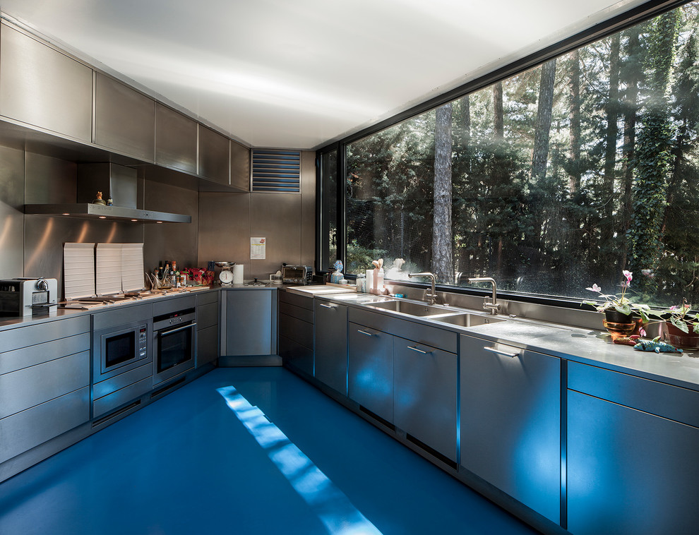 Design ideas for an expansive contemporary u-shaped enclosed kitchen in Madrid with a double-bowl sink, flat-panel cabinets, stainless steel cabinets, stainless steel worktops, metallic splashback, metal splashback, stainless steel appliances and no island.