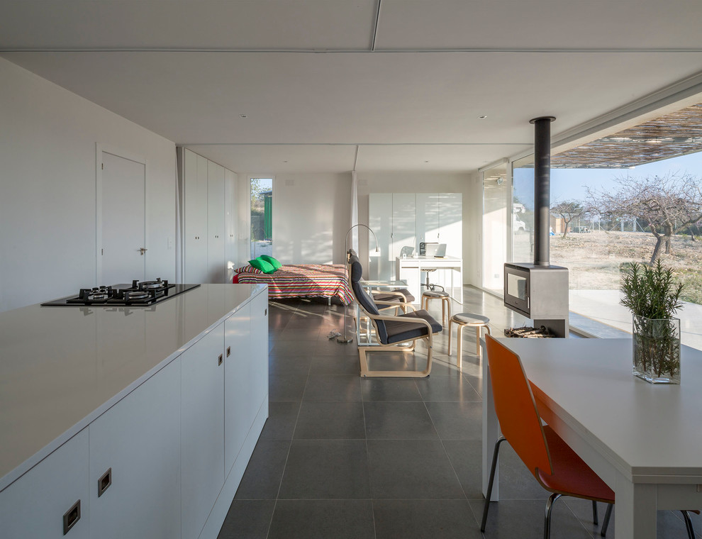 Foto de cocina lineal contemporánea de tamaño medio abierta con armarios con paneles lisos, puertas de armario blancas, suelo de baldosas de cerámica y una isla