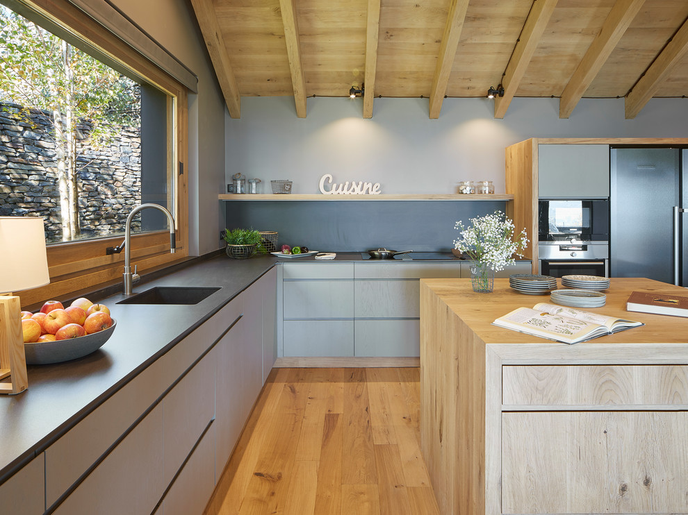 Foto de cocina de estilo de casa de campo grande abierta con suelo de madera clara, encimera de piedra caliza y una isla
