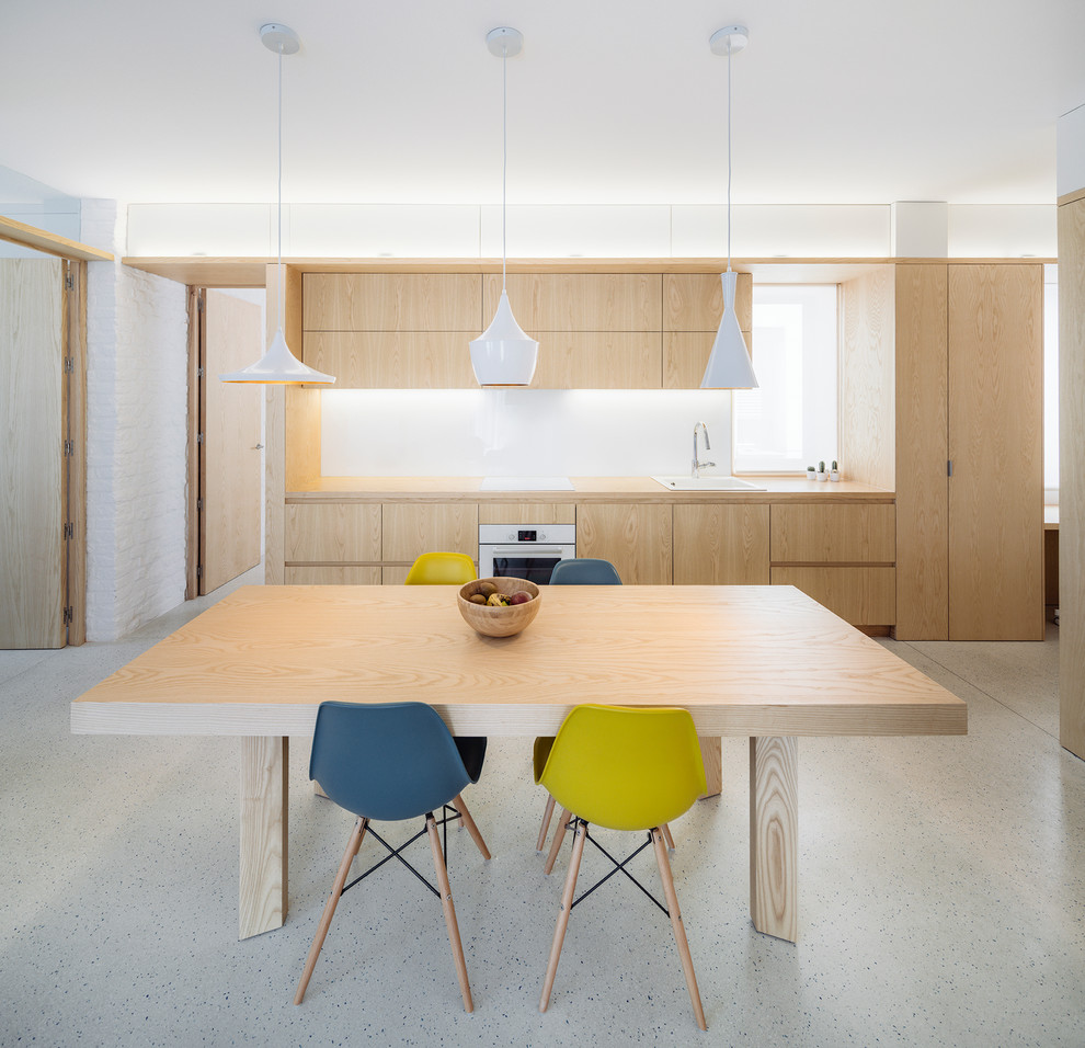 This is an example of a medium sized scandi single-wall kitchen/diner in Madrid with flat-panel cabinets, light wood cabinets, wood worktops, white splashback, glass sheet splashback, white appliances and no island.