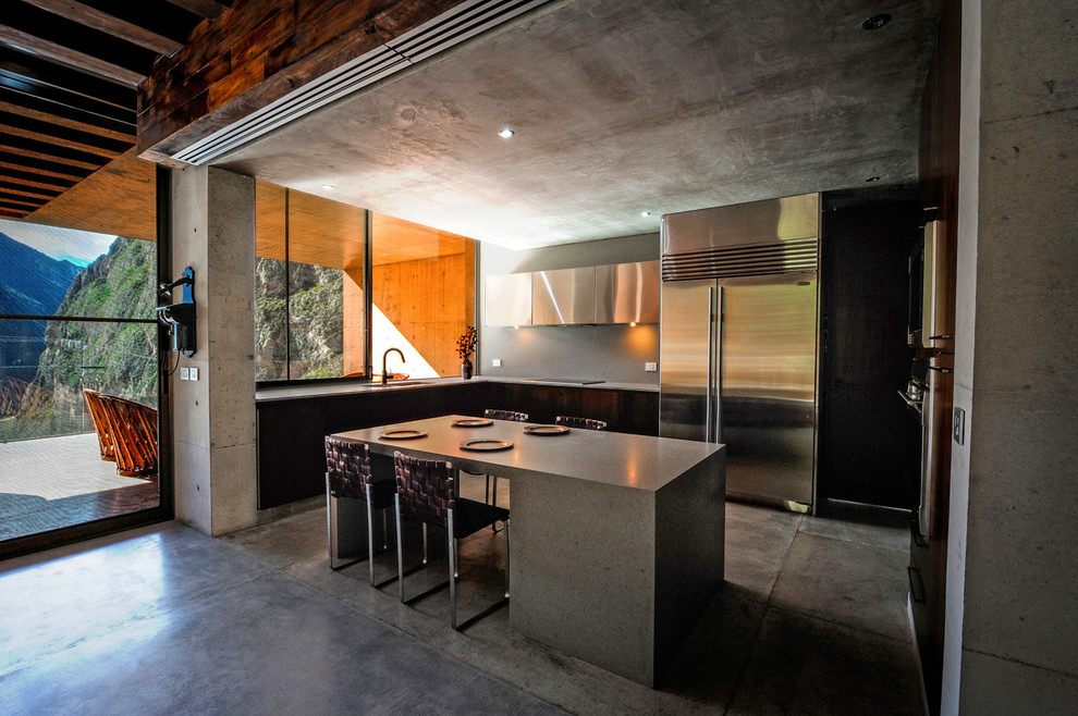 Идея дизайна: п-образная кухня в стиле модернизм с плоскими фасадами, столешницей из бетона, серым фартуком, техникой из нержавеющей стали, бетонным полом и островом