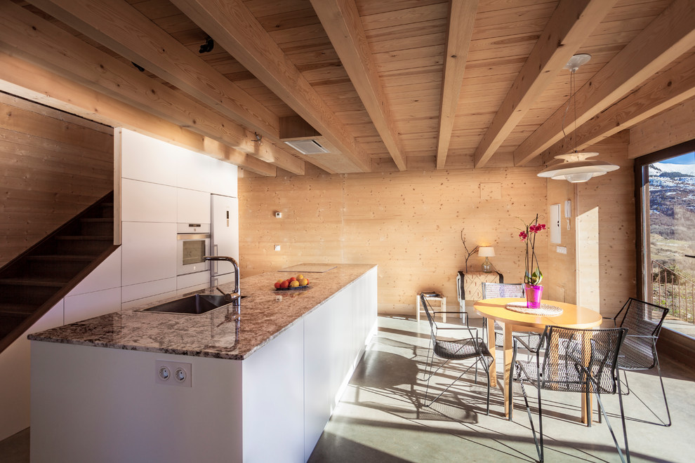 Idéer för att renovera ett mellanstort lantligt linjärt kök och matrum, med släta luckor, vita skåp, granitbänkskiva, vita vitvaror, en köksö, grått golv, en nedsänkt diskho och betonggolv