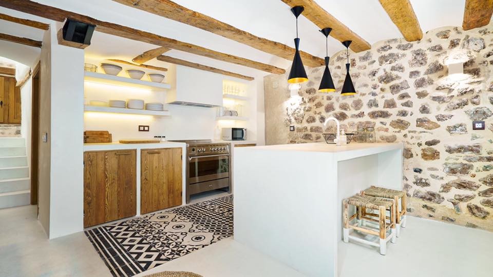 This is an example of a medium sized mediterranean single-wall open plan kitchen in Valencia with a built-in sink, recessed-panel cabinets, medium wood cabinets, concrete worktops, white splashback, stainless steel appliances, concrete flooring, an island and white floors.