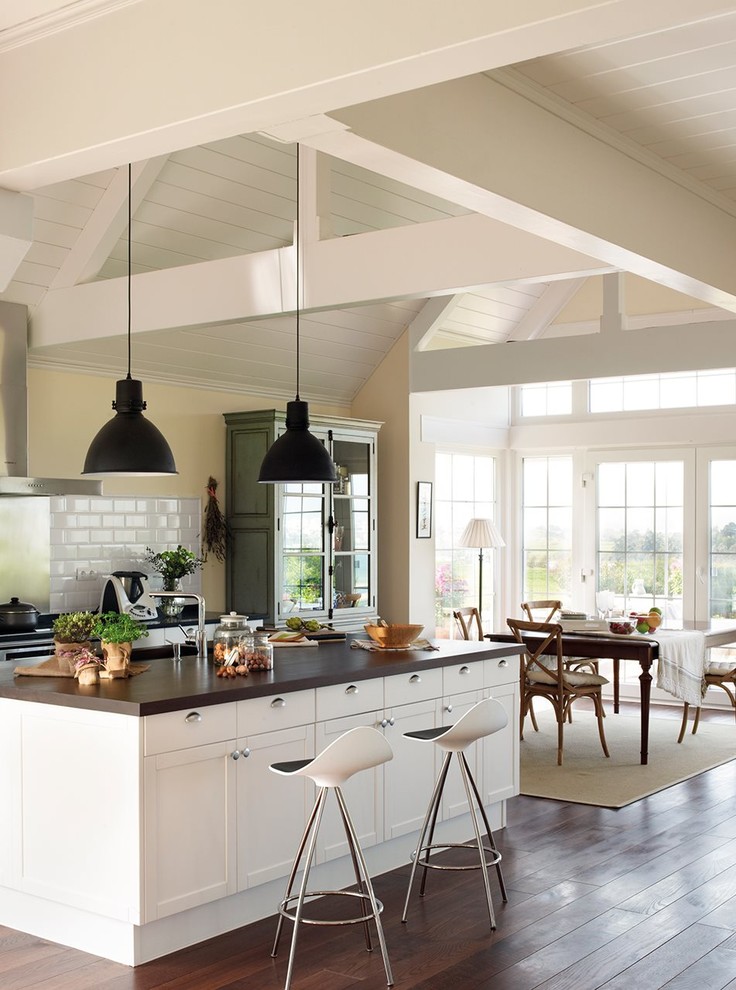Inspiration for a mid-sized timeless single-wall dark wood floor open concept kitchen remodel in Other with a single-bowl sink, beaded inset cabinets, white cabinets, wood countertops, white backsplash, porcelain backsplash, white appliances and an island
