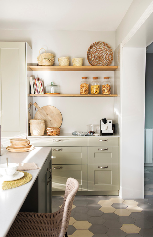 Immagine di una cucina chic di medie dimensioni con lavello da incasso, nessun'anta, ante beige, elettrodomestici in acciaio inossidabile, pavimento in gres porcellanato, pavimento beige e top bianco
